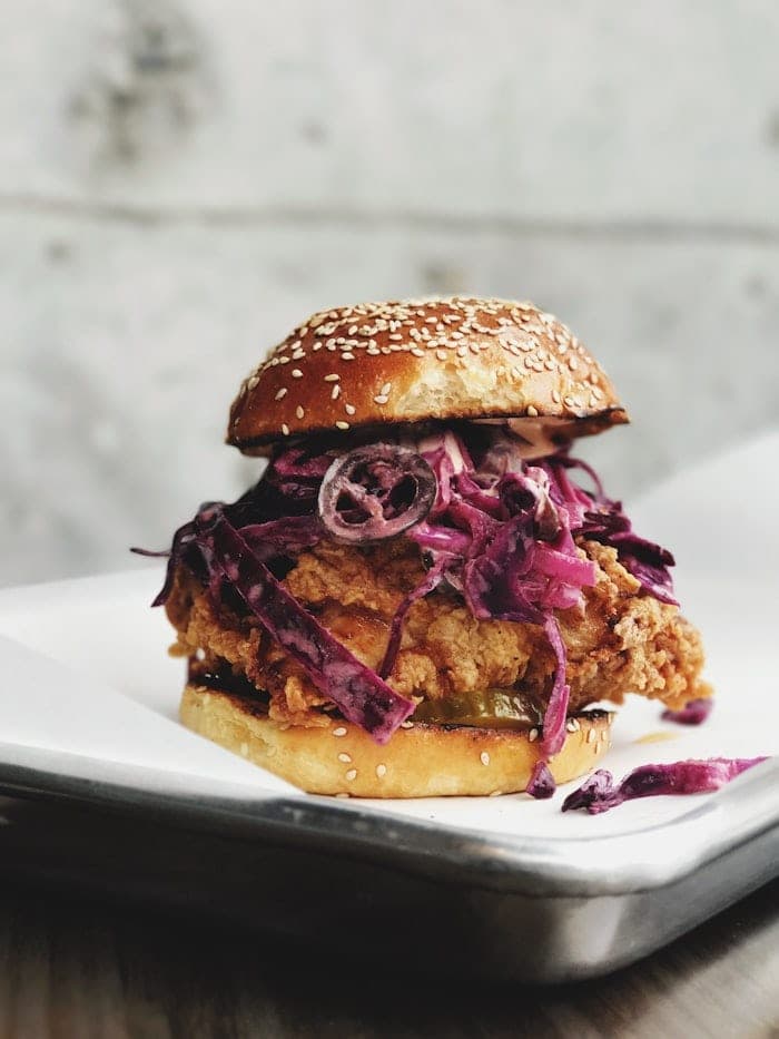 Crispy chicken burger with purple slaw on a sesame bun