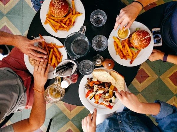 Friends sharing burgers and fries around a table