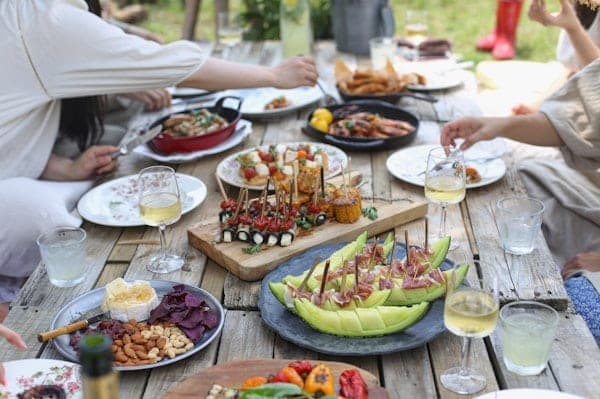 Shared dishes on a long outdoor table at a gathering