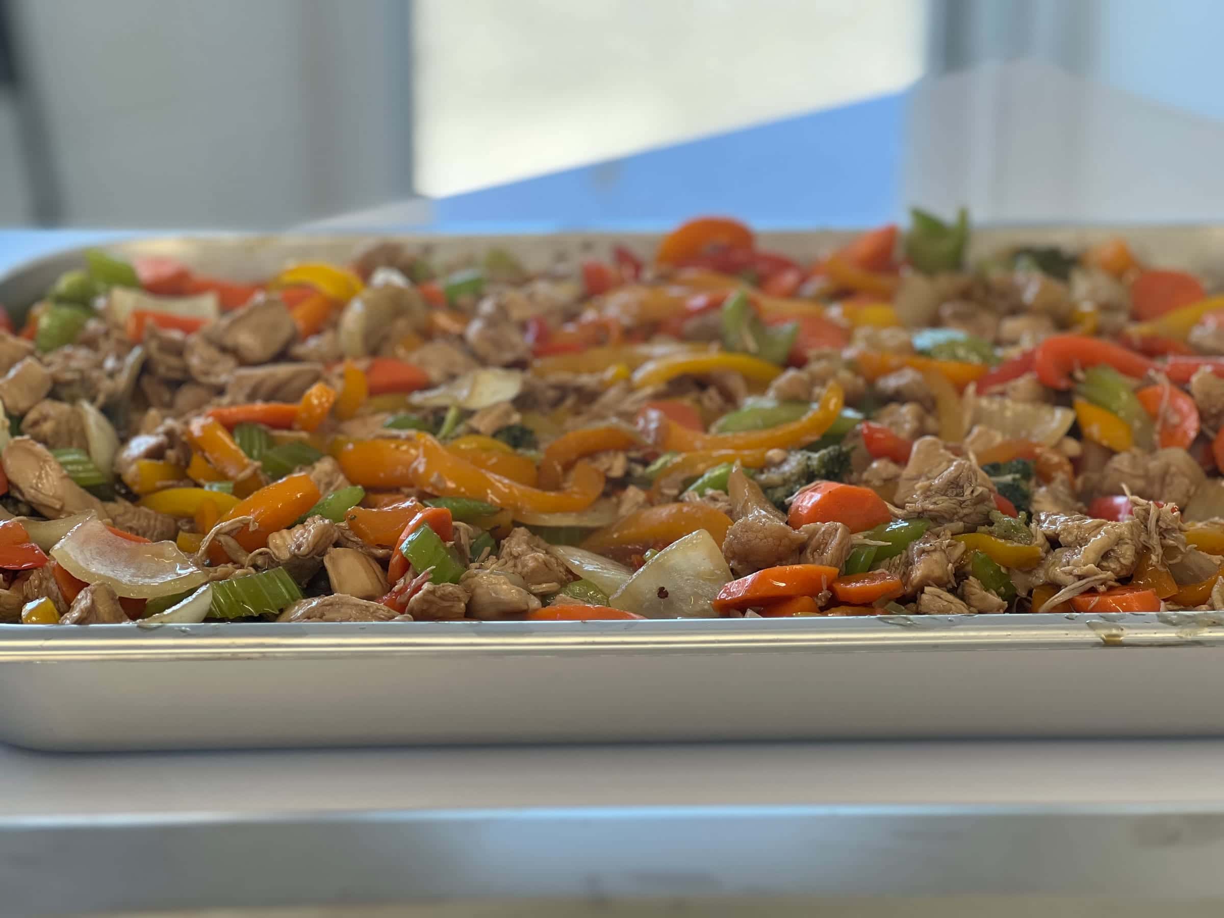 Tray of freshly prepared chicken with peppers, carrots and celery